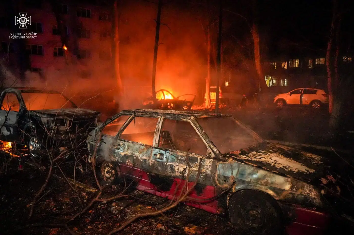 Billedet viser ødelagte biler ved en brændende boligblok i Odessa efter et russisk droneangreb.