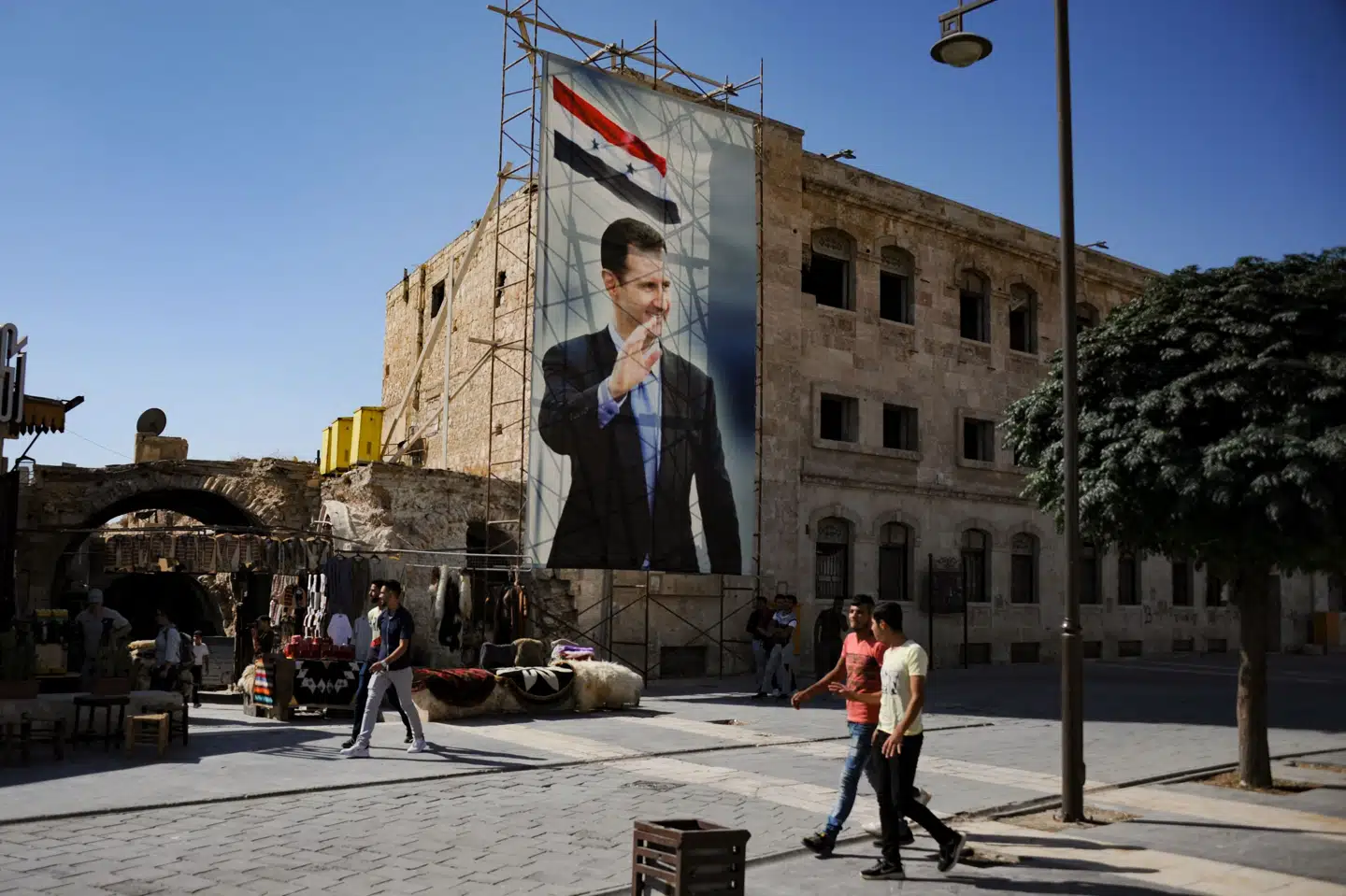 En stor plakat med et billede af Syriens præsident, Bashar al-Assad, hænger på en mur i den gamle bydel i Aleppo. I Holland har en domstol mandag for første gang dømt en tidligere syrisk soldat fra Assads regeringshær for krigsforbrydelser begået under den langvarige krig i Syrien. (Arkivfoto)