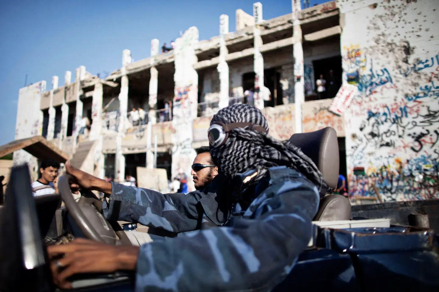 Libyske oprørere kører forbi det tidligere kombineret palads og militærbase i hovedstaden Tripoli efter at have indtaget byen i efteråret 2011.