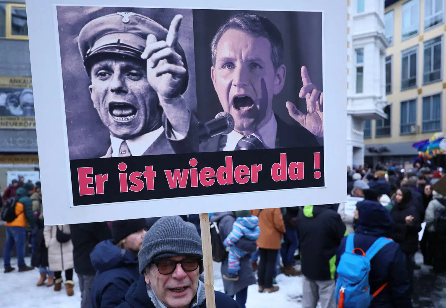 En demonstrant med en plakat, som viser Nazitysklands propagandaminister Joseph Goebbels og Björn Höcke, en af frontfigurerne i Alternative für Deutschland. »Han er tilbage,« står der på skiltet.