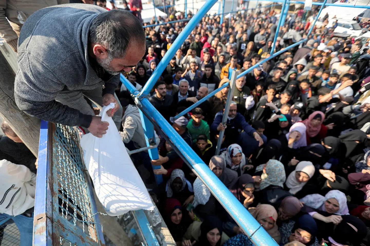 en palæstinensisk mand holder en pose mel, mens mange andre venter på at få deres nødhjælp fra UNRWA i den sydlige del af Gazastriben. (Arkivfoto)