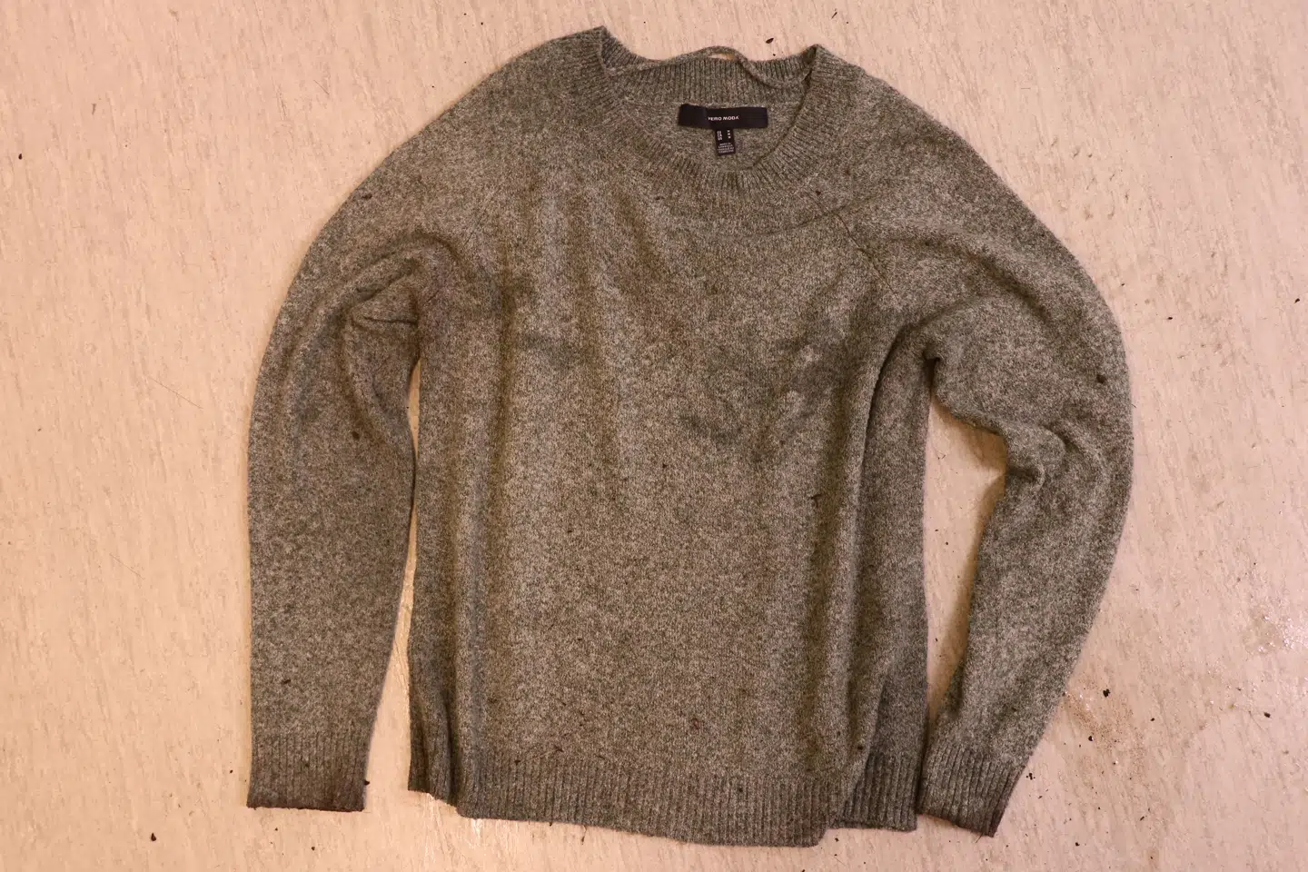 Kvindens trøje er mørkegrøn og størrelse M fra Vero Moda.