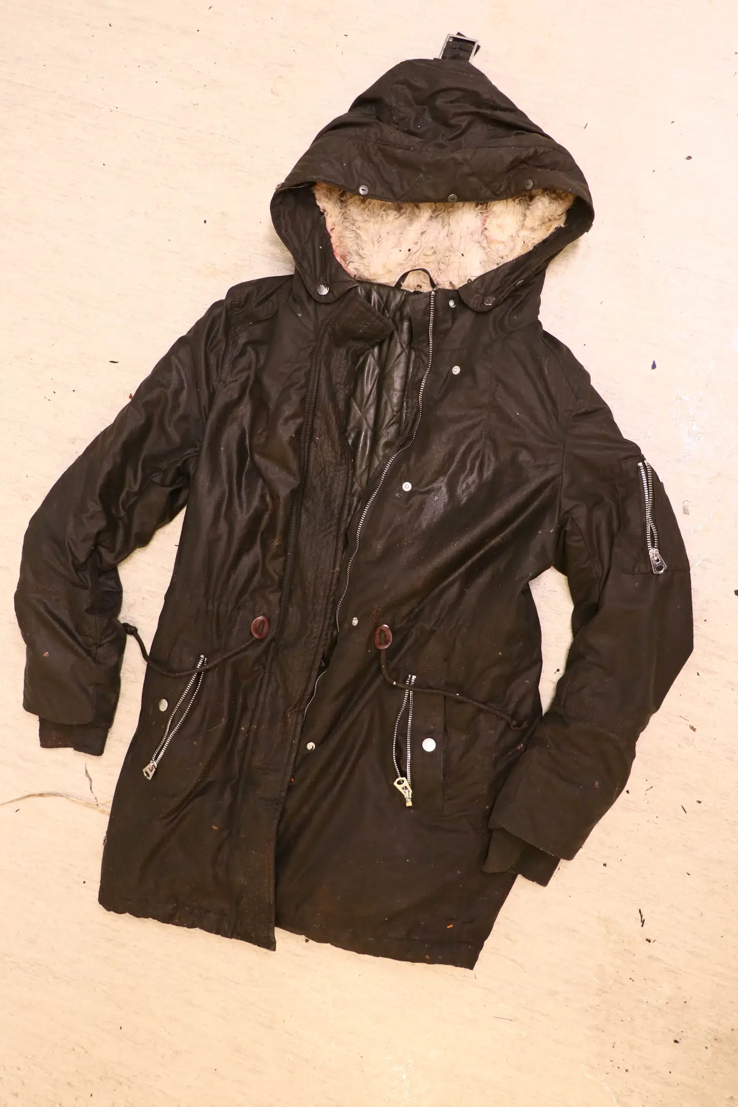 Vinterjakken er mørkegrøn med snører i livet og hvidt for i hætten.