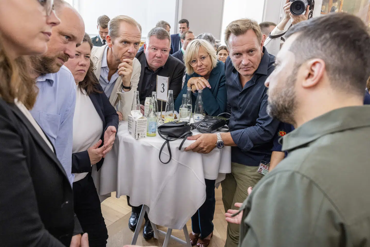 Ved et bord står flere danske chefredaktører og Zelenskyj tager sig god tid til at besvare deres spørgsmål. Fra venstre: Marchen Neel Gjertsen fra Jyllands-Posten, Knud Brix fra Ekstra Bladet, Pernille Holbøll fra (dengang) B.T., Christian Jensen fra Politiken, Tom Jensen fra Berlingske, Ulla Pors og Rasmus Tantholdt fra TV 2.)