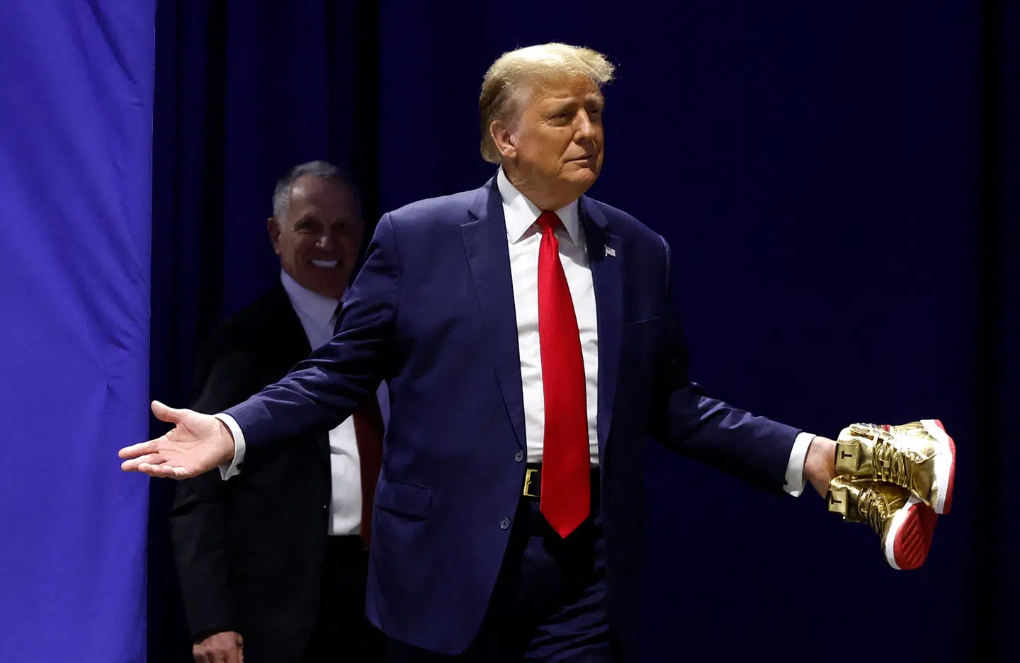 Donald Trump med et par af de guldsneakers, som man nu kan få fingrene i for kun 399 dollar. Foto: Chip Somodevilla, AFP / Scanpix