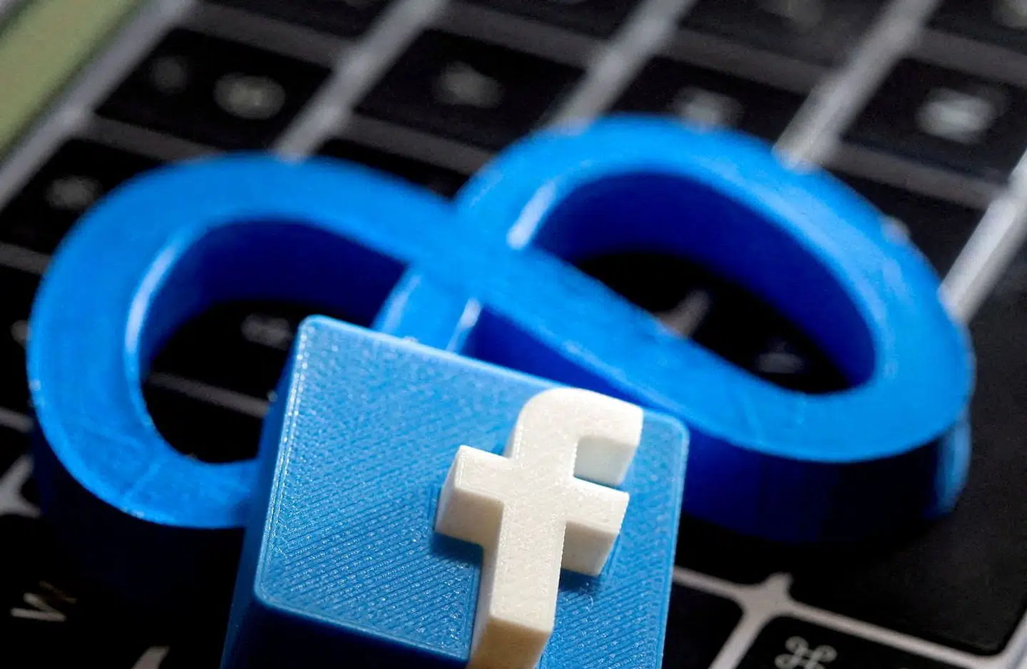 FILE PHOTO: 3D-printed images of the logos of Facebook and parent company Meta Platforms are seen on a laptop keyboard in this illustration taken on November 2, 2021. REUTERS/Dado Ruvic/File Photo