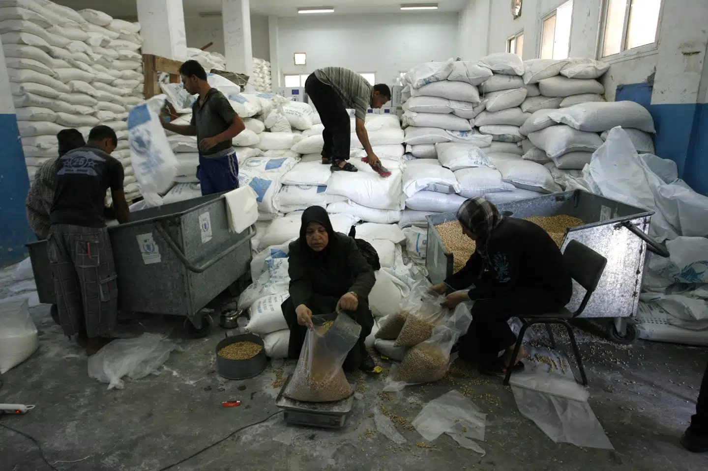 Verdens Fødevareprogram (WFP) leverer nødhjælp i form af mad til kriseramte områder. Her ses lokale gøre sække med mel og bælgfrugter klar til uddeling som en del af fødevarehjælpen fra WFP i det sydlige Gaza. Mandag meddeler WFP, at levering af nødhjælp må sættes på pause i det nordlige Gaza.