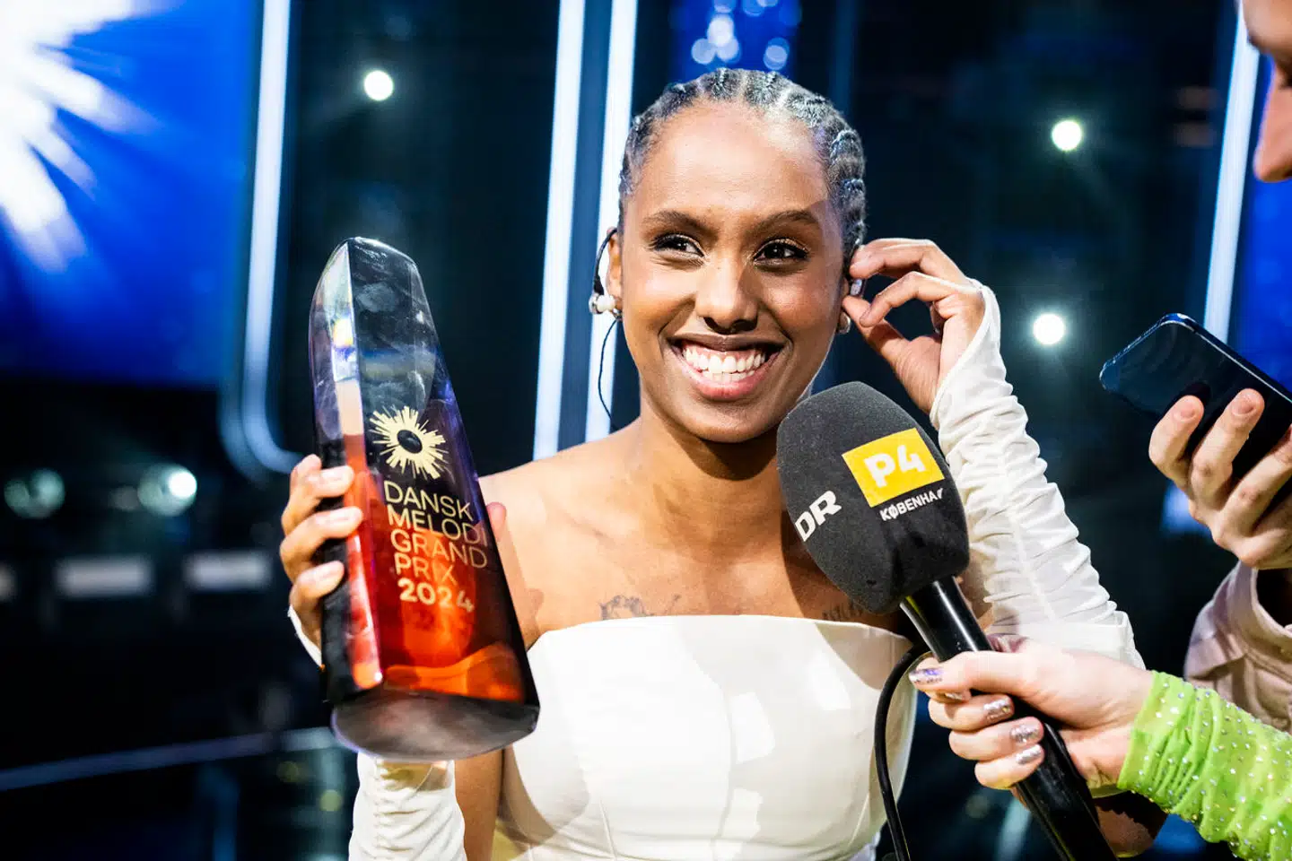 »At stille op i Dansk Melodi Grand Prix eller Eurovision som kunstner er ikke at tage stilling til politiske spørgsmål. Det er heller ikke at erklære sig enig med DR i alt. Det er at udøve sin kunst,« skriver Gustav Lützhøft. SABA med det borgerlige navn Saba Lykke Oehlenschlæger vandt med sangen »Sand« Dansk Melodi Grand Prix 2024.