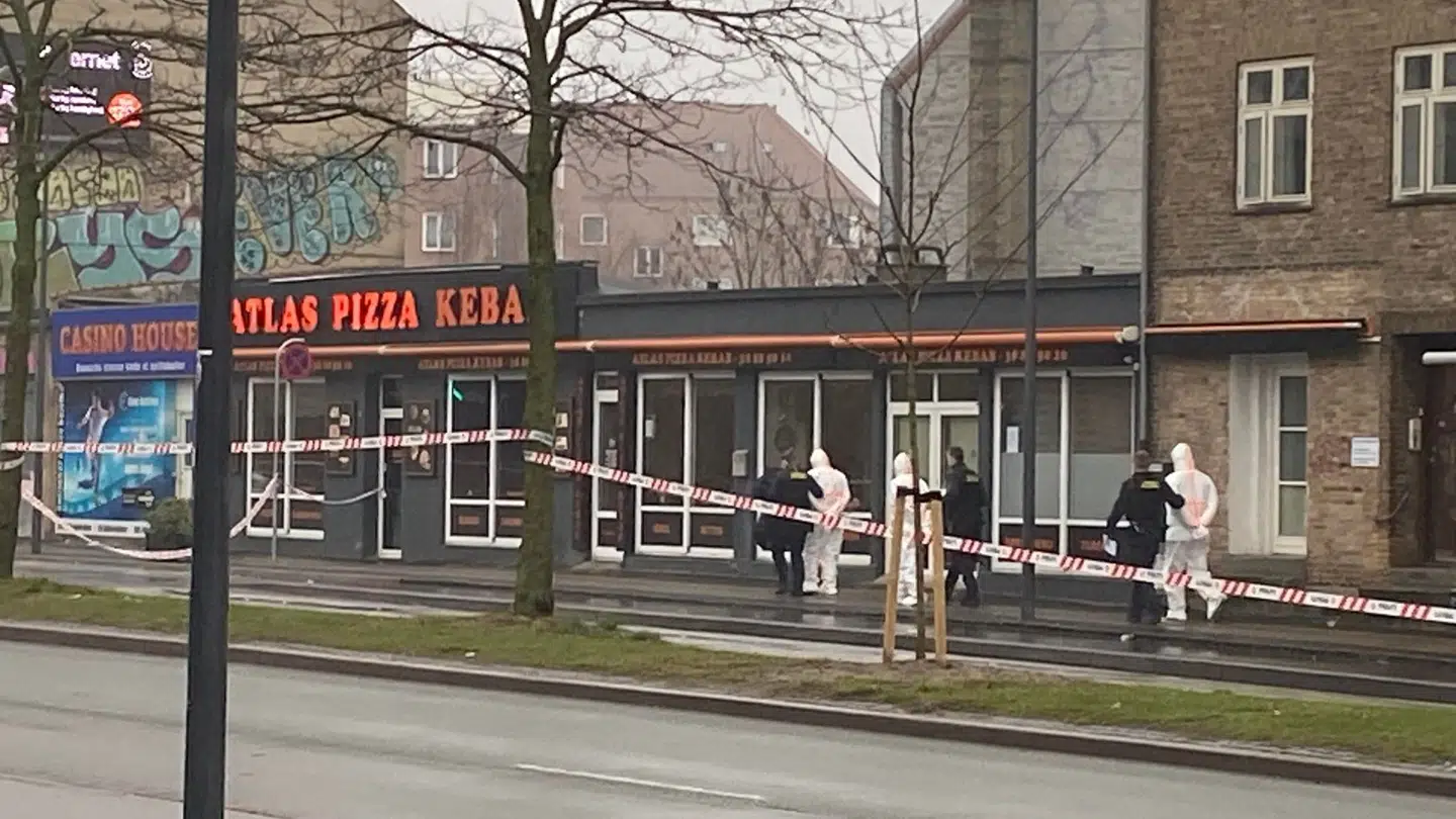 Personer i dna-dragt bliver ført væk af politiet.