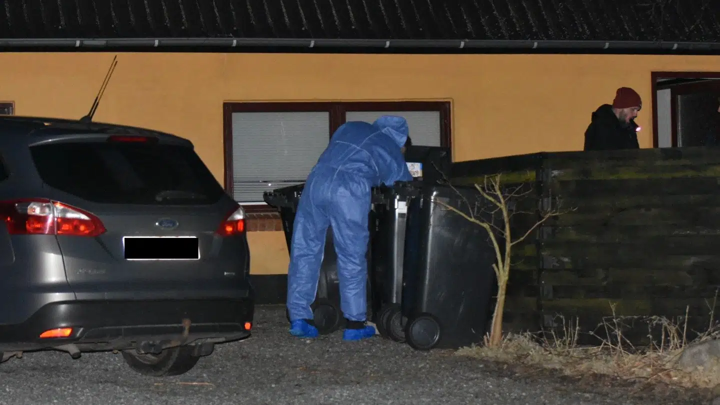 Her ses en kriminaltekniker rode i en skraldespand ved hjemmet, hvor de to personer blev fundet døde.