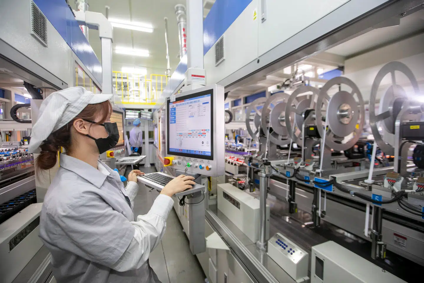 A mask-clad woman works at a subsidiary of Longi, a major solar panel manufacturer, in Taizhou in east China's Jiangsu province Thursday, Dec. 15, 2022. (FeatureChina via AP Images)