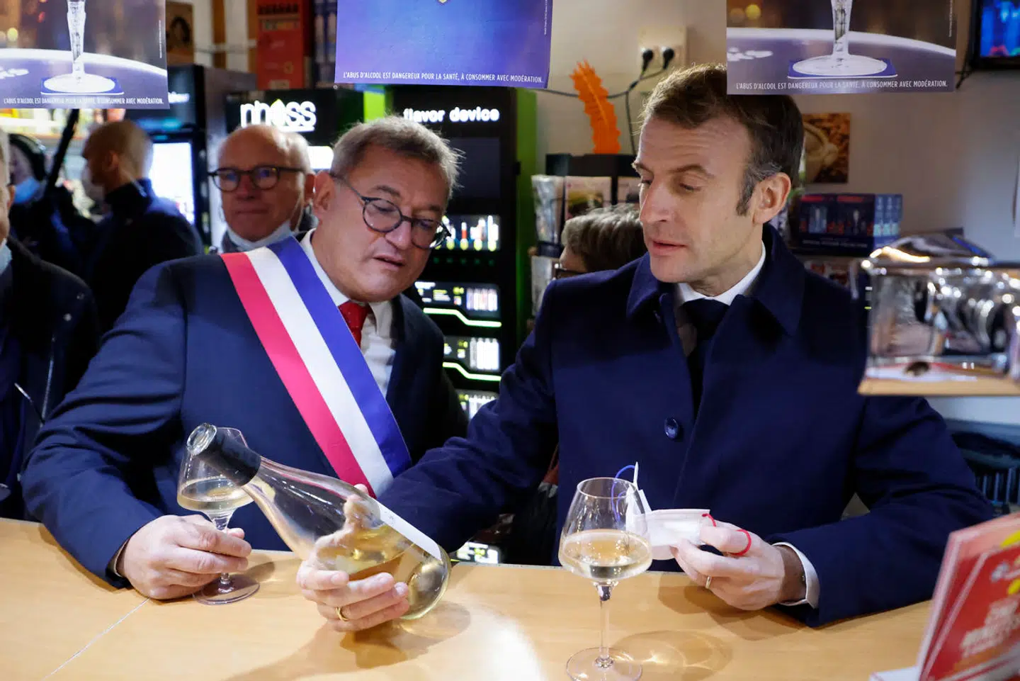 Emmanuel Macron får sig et glas med borgmesteren under et besøg i midtfranske Vierzon. Men den vinglade præsident er ude af trit med især sine yngste landsmænd, når det handler om smagen for Frankrigs nationaldrik.