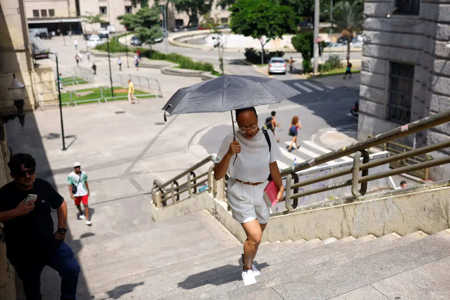En kvinde søger skygge under en hedebølge i Sao Paulo, Brasilien. Arkivfoto: Amanda Perobelli, Scanpix