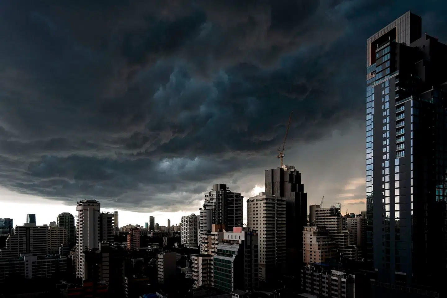 Dark clouds loom over the Bangkok skyline on August 18, 2022. (Photo by MANAN VATSYAYANA / AFP)