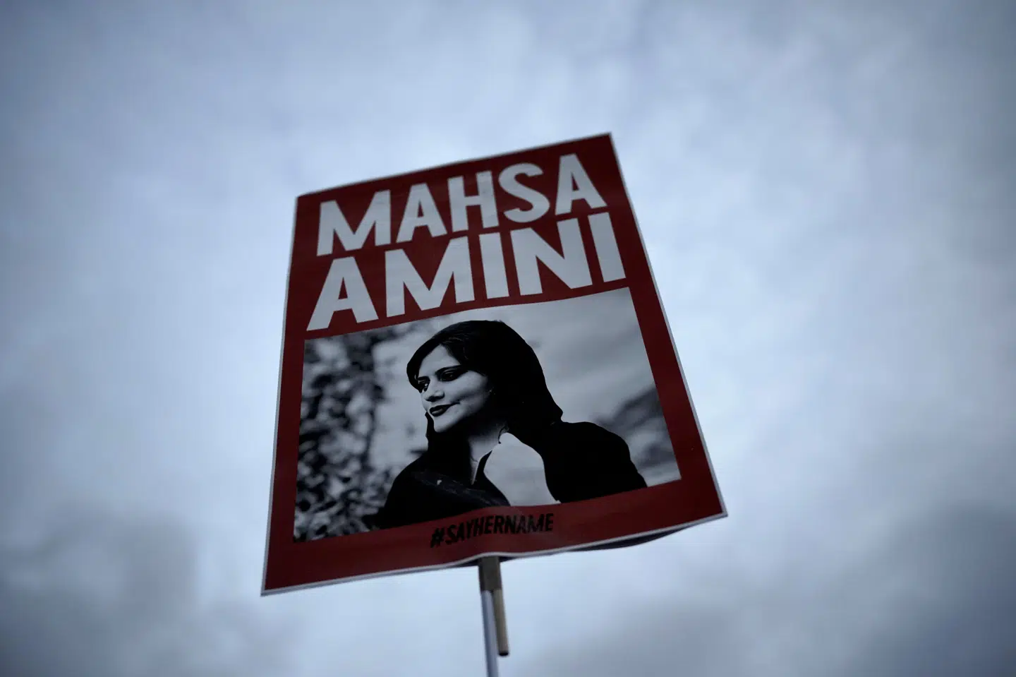 En kvinde holder en plakat med et billede af den 22-årige Mahsa Amini, som døde i det iranske moralpolitis varetægt. Hun lå i koma i tre dage før sin død. Hun var blevet anholdt, fordi hendes hijab ifølge de iranske myndigheder ikke dækkede hendes hår. Hun er blevet et symbol på mostanden mod det konservative styre i Teheran.