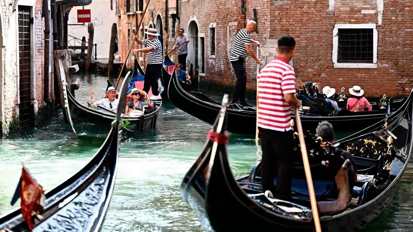 Turister på tur i et af Venedigs varemærker; de berømte gondoler.