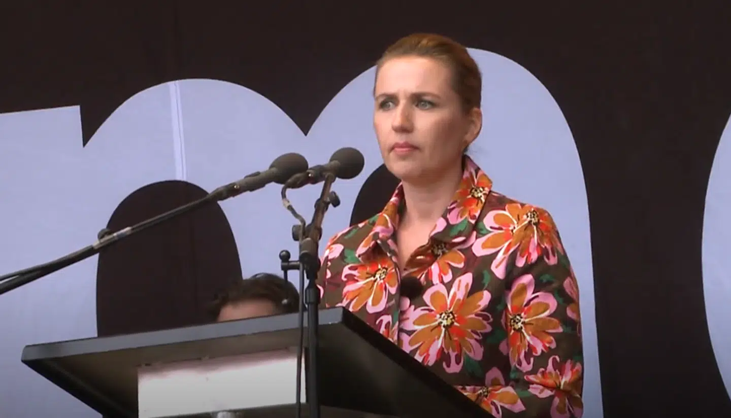 Mette Frederiksen ser vredt ned på folk, der slås foran scenen i Fælledparken i 2019.