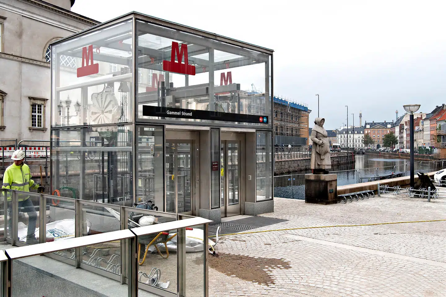 »Fiskerkonen« (i baggrunden) fra 1939 kigger ud over den nye plads med sin rødspætte i hånden - som en reminiscens fra dengang, der blev solgt fisk her på Gammel Strand. Anderledes ser det ud i dag, hvor rødspætten kan indtages tilberedt på Krogs Fiskerestaurant, kaffen på Diamanten, burgeren på Cock's & Cows og cocktailen på Madam Chu's - for at nævne nogle få. På grund af de mange beværtninger frygter flere beboere, at den nye metroring vil medføre mere larm og støj.