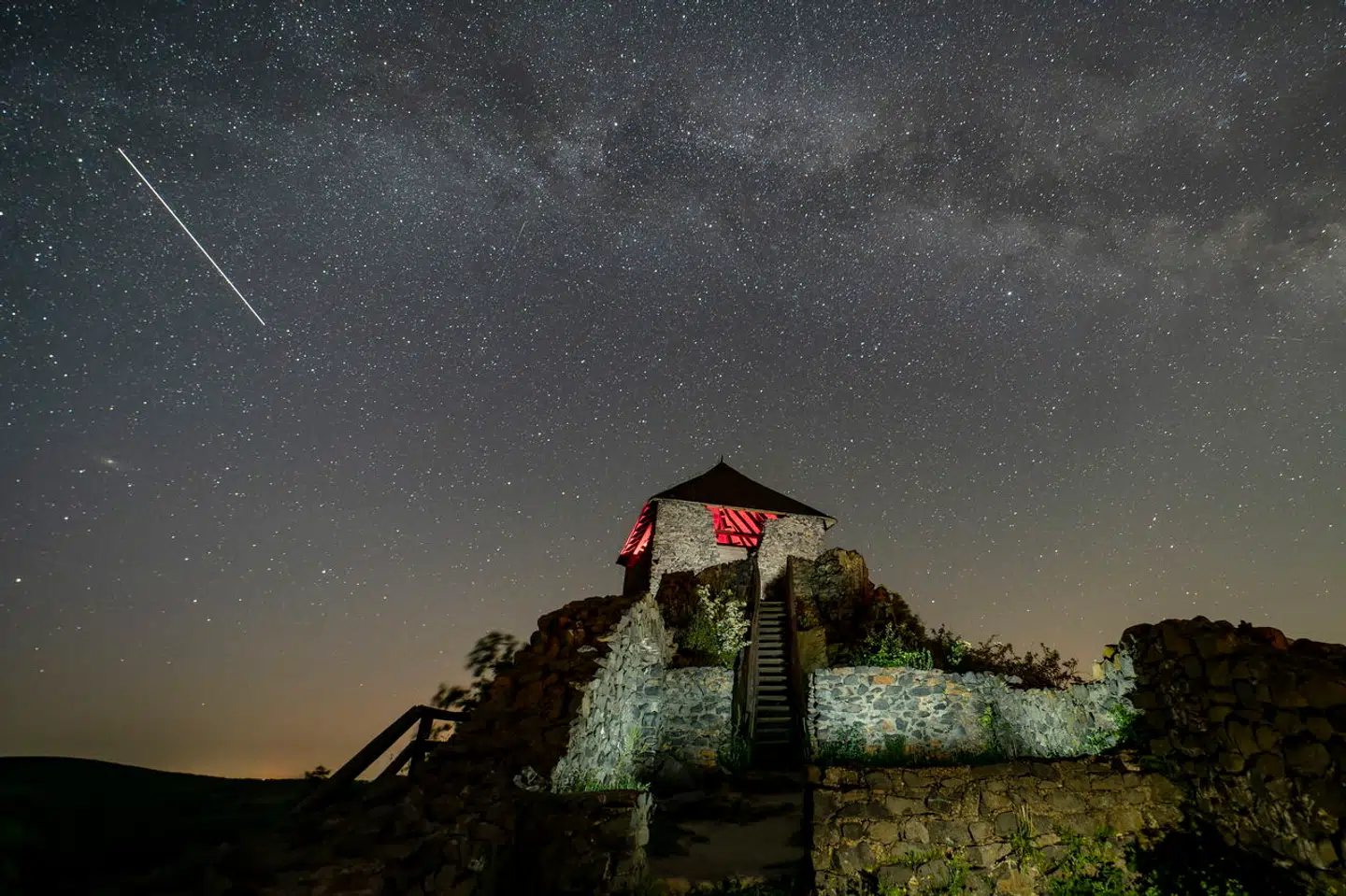 epa11319383 A long exposure photograph shows a meteor (top-L) in the sky above the Salgo Castle (C) near Salgotarjan, northern Hungary, early 05 May 2024, during the peak of the Eta Aquariids meteor shower. The meteor shower, which is associated with Halley's Comet, is usually visible from the second half of April to the end of May annually. EPA/PETER KOMKA HUNGARY OUT