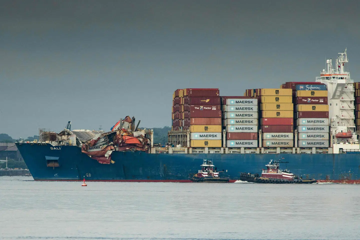 Slæbebåde bringer containerskibet "Dali" til havnen i Baltimore.