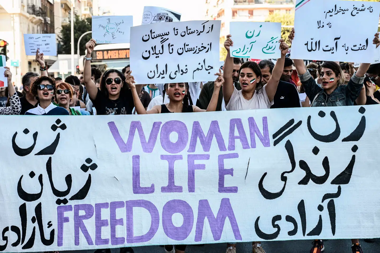 I kølvandet på Mahsa Jina Aminis død i de iranske myndigheders vartægt gik unge iranere på gaden over hele verden i protest mod præstestyret. Her ses iranske kvinder i Grækenland bag et banner med skriften »Kvinde, liv, frihed«. Foto: Sakis Mitrolidis, Scanpix