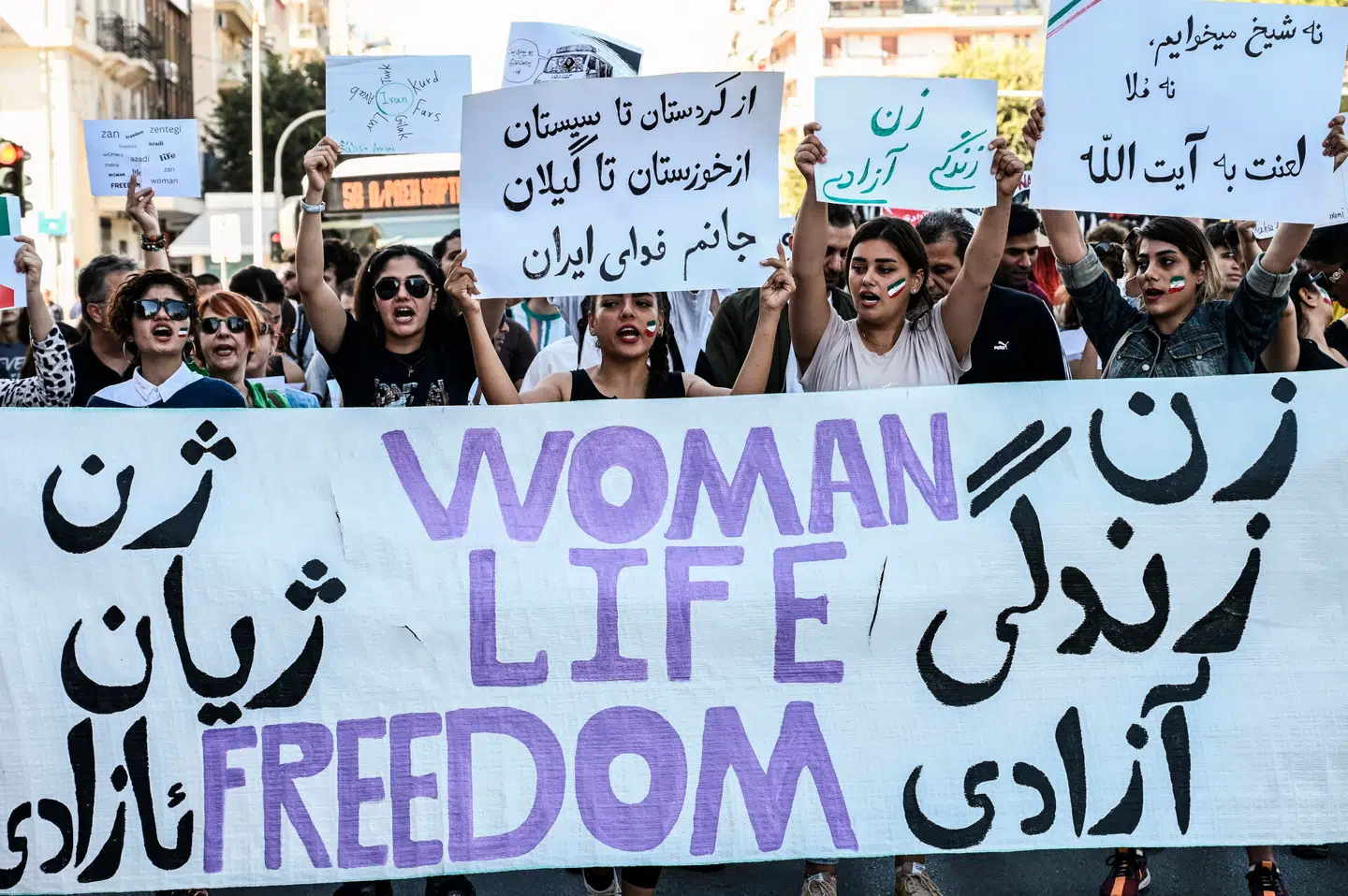 I kølvandet på Mahsa Jina Aminis død i de iranske myndigheders vartægt gik unge iranere på gaden over hele verden i protest mod præstestyret. Her ses iranske kvinder i Grækenland bag et banner med skriften »Kvinde, liv, frihed«. Foto: Sakis Mitrolidis, Scanpix