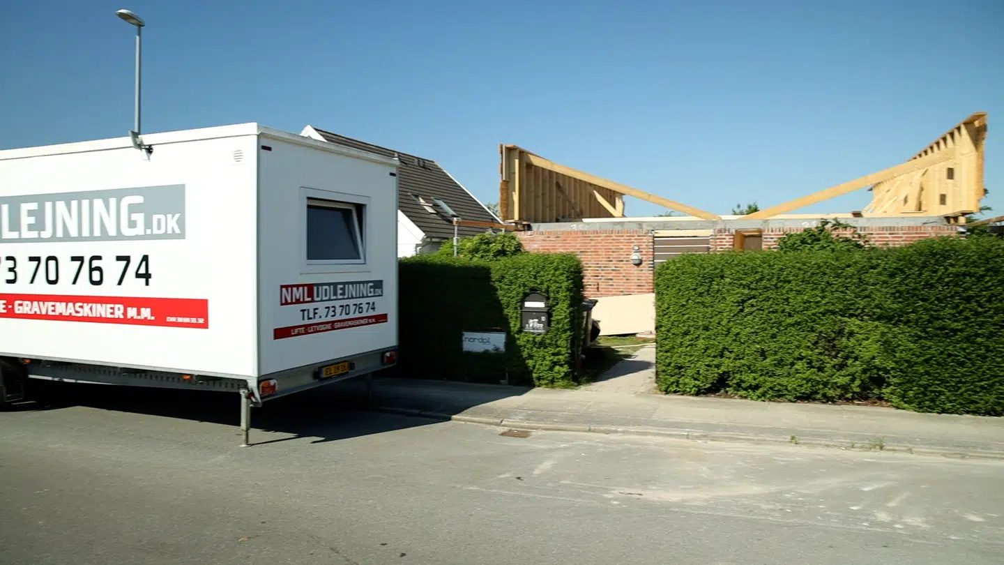 Familien Hartmann bir stadig i den hvide skurvognen på vejen foran deres husombygning.