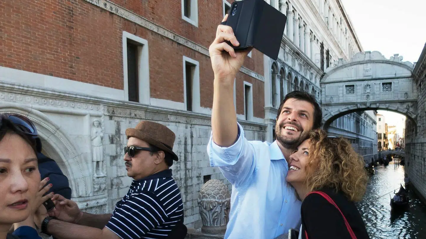 Der er så mange turister i Venedig, at det truer med at ødelægge byen. Her tager nogle af dem selfies ved Sukkenes bro i baggrunden i 2019 – året, hvor antallet af besøgende nåede sit foreløbige højdepunkt.