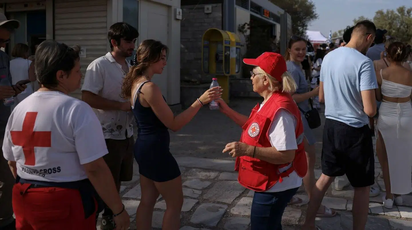 Røde Kors deler vand ud til turister i Athen.