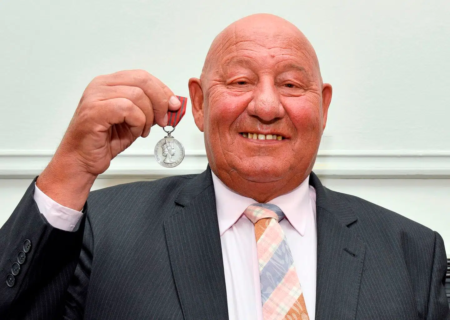 Den tidligere bokser Ronnie Russell - som var dagens helt - poserer i 2020 med den medalje, han fik for sin uselviske dåd.