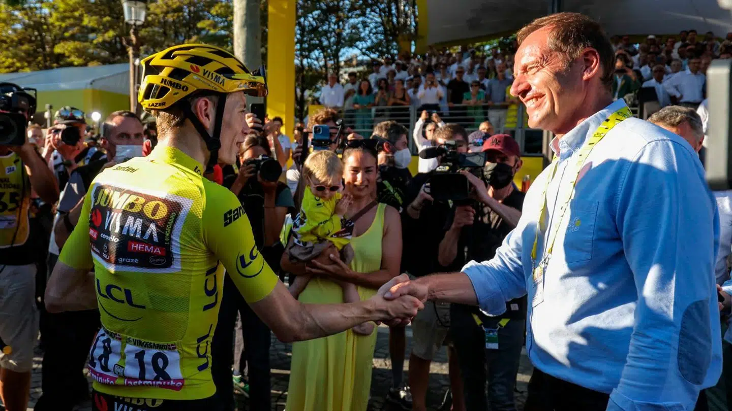 Jonas Vingegaard hilser her på Tour-direktør Christian Prudhomme foran cykelstjernens hustru, Trine.