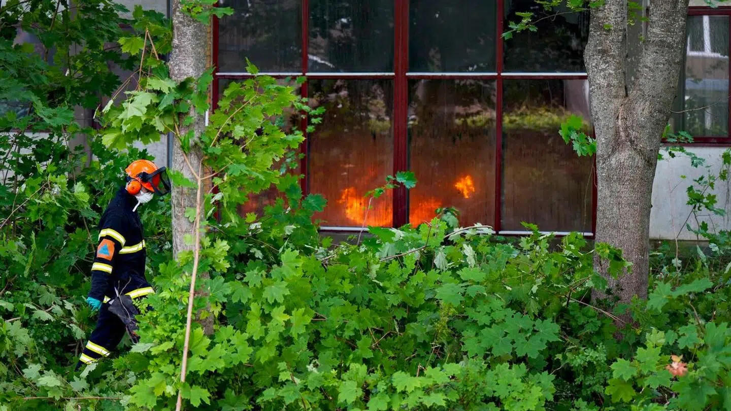 Brandfolkene arbejder på ydersiden af bygningen.