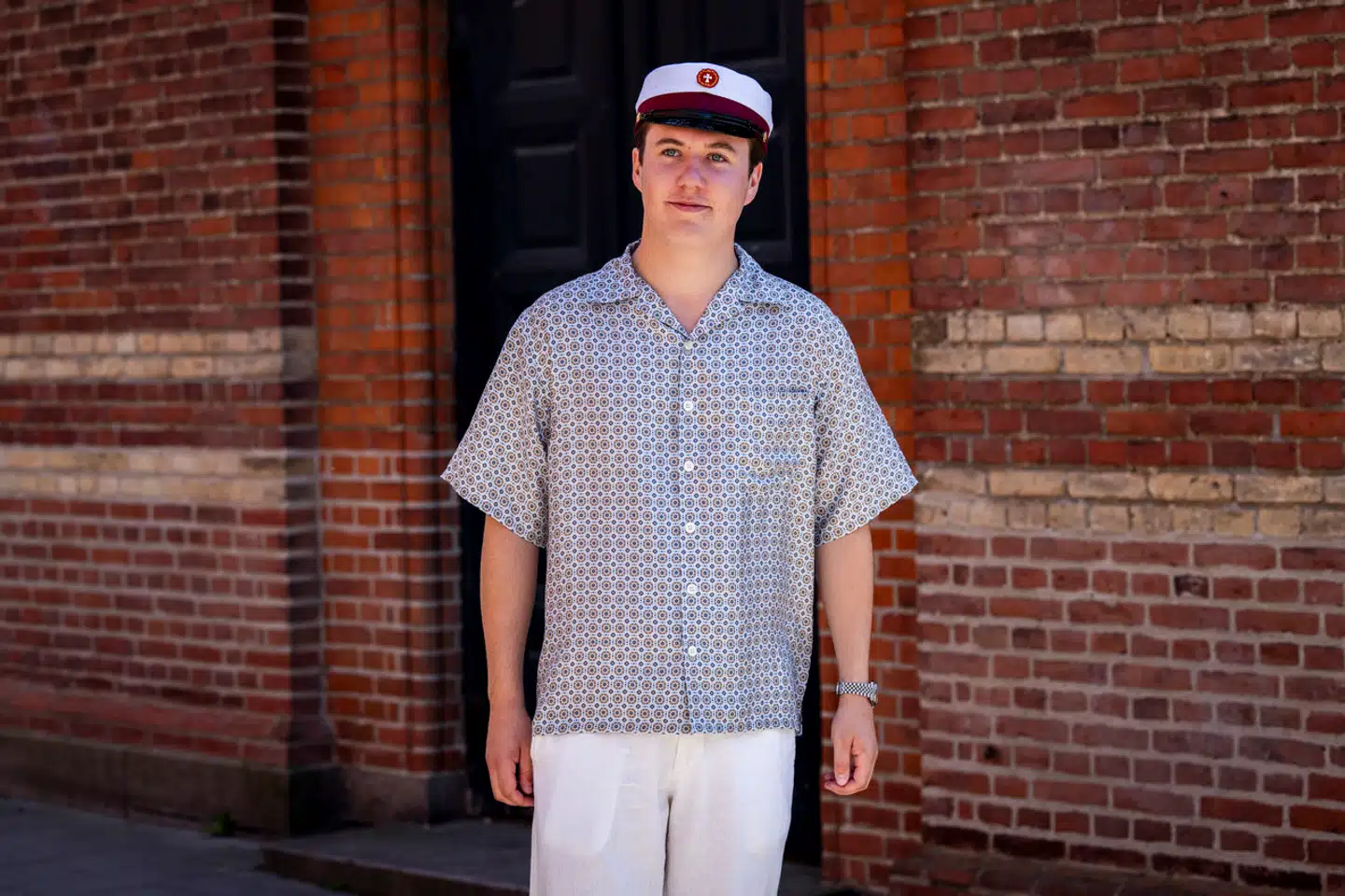 Kronprins Christian med huen på hovedet, da han 24. juni blev student fra Ordrup Gymnasium. Det er skjorten, som Kronprinsen bærer på billedet, som har antændt en debat.