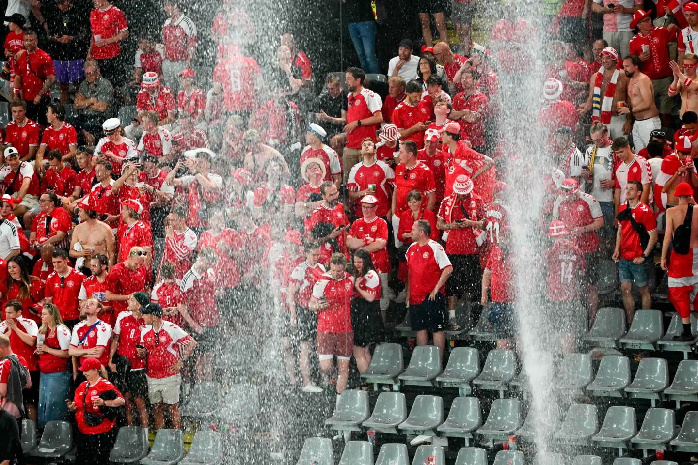 Danske fans forholder sig roligt, mens de venter på, at regnen stilner af i Dortmund. Foto: Alberto Pizzoli, Scanpix.