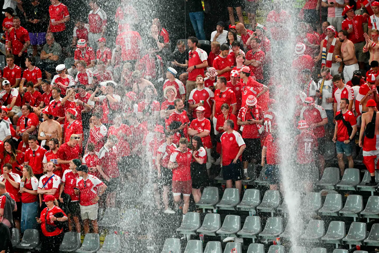 Danske fans forholder sig roligt, mens de venter på, at regnen stilner af i Dortmund. Foto: Alberto Pizzoli, Scanpix.