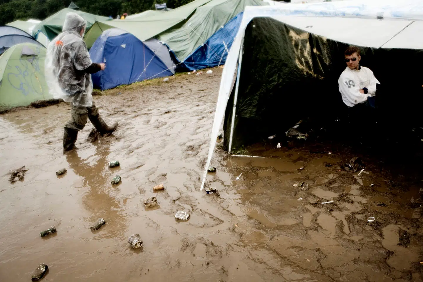 Roskilde Festival 2007. Festivaldeltagere har søgt ly for regnen i et primitivt telt.