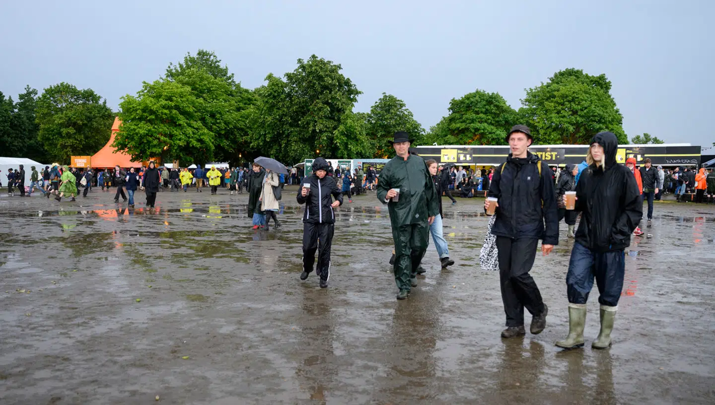 Festivalgæster på festivalpladsen foran Orange scene efter regnen lørdag aften.