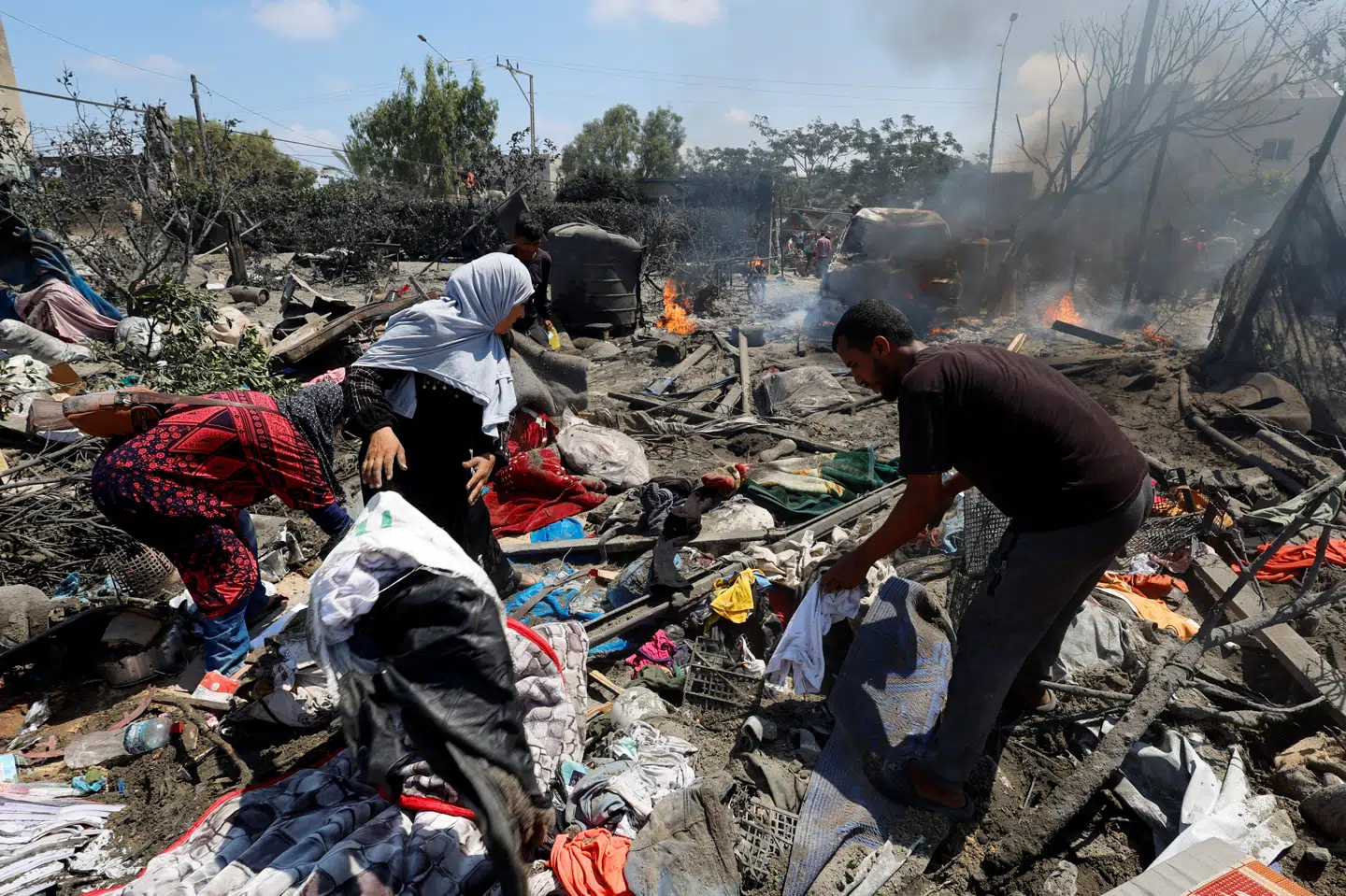 Palæstinensere undersøger området i teltlejren al-Mawesi i Khan Younis, som er blevet angrebet lørdag.