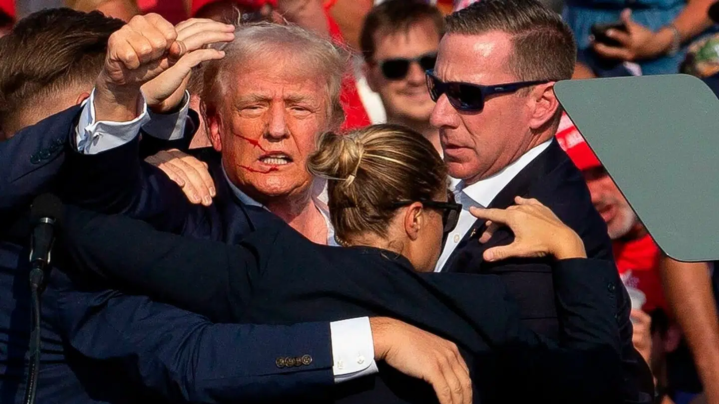 Her ses Donald Trump med blod i ansigtet, efter kuglen strejfede hans øre under et vælgermøde natten til søndag.