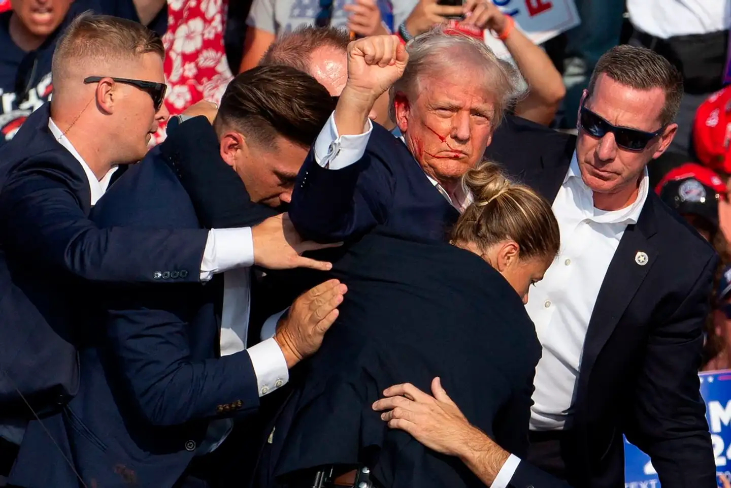 Donald Trump bliver eskorteret væk fra agenter fra Secret Service med blodspor i ansigtet.