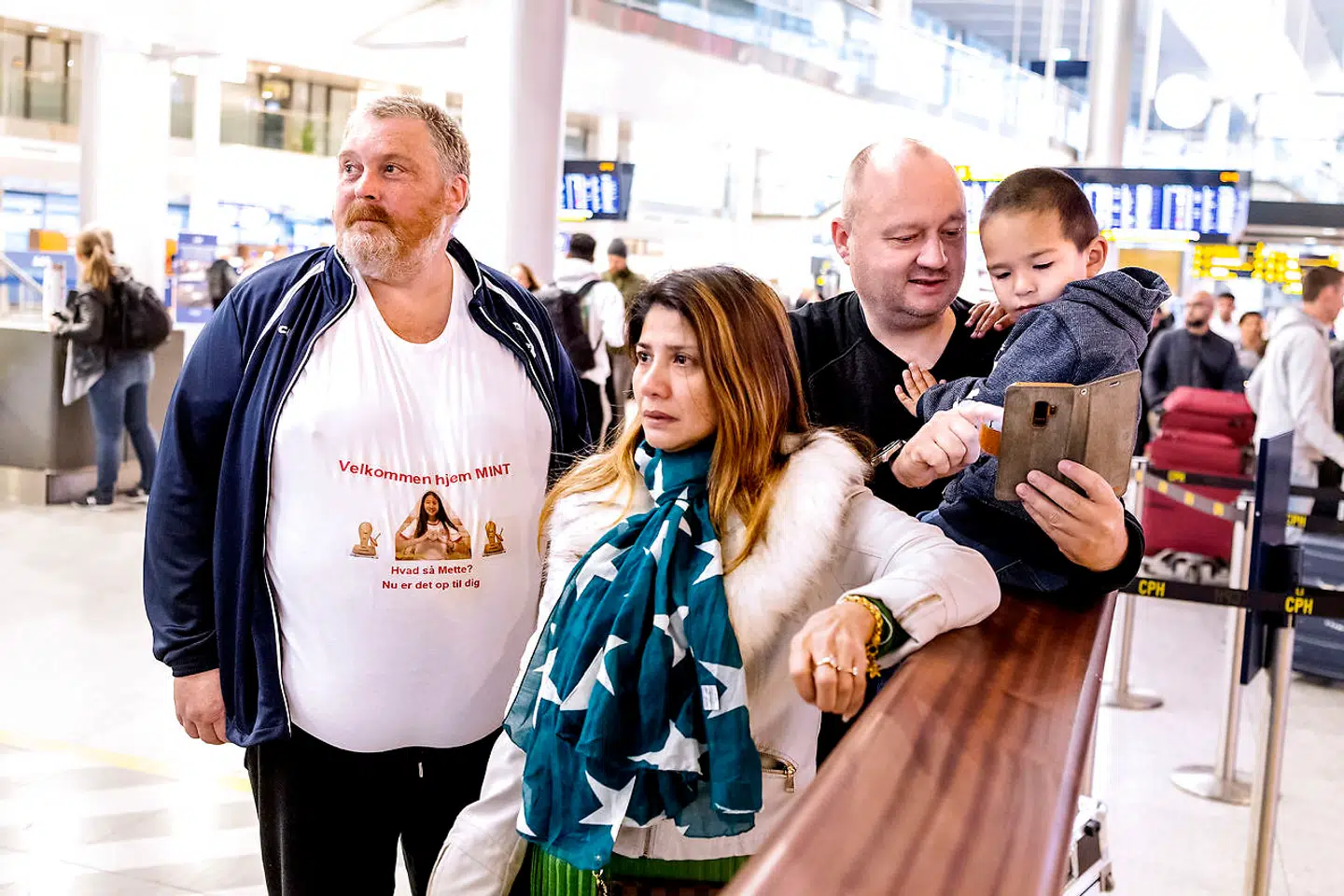 Far, mor, lillebror og fars ven venter på Mint i ankomsthallen.