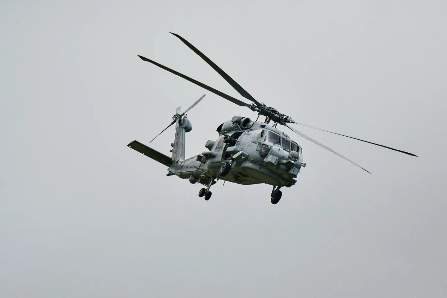 En Seahawk-helikopter ses i luften ved Flyvestation Karup i juni 2022. Besparelser betyder ifølge DR, at Helicopter Wing i Karup må aflyse en militærøvelse, ligesom Air Transport Wing i Aalborg også må aflyse øvelser og simulatortræning.