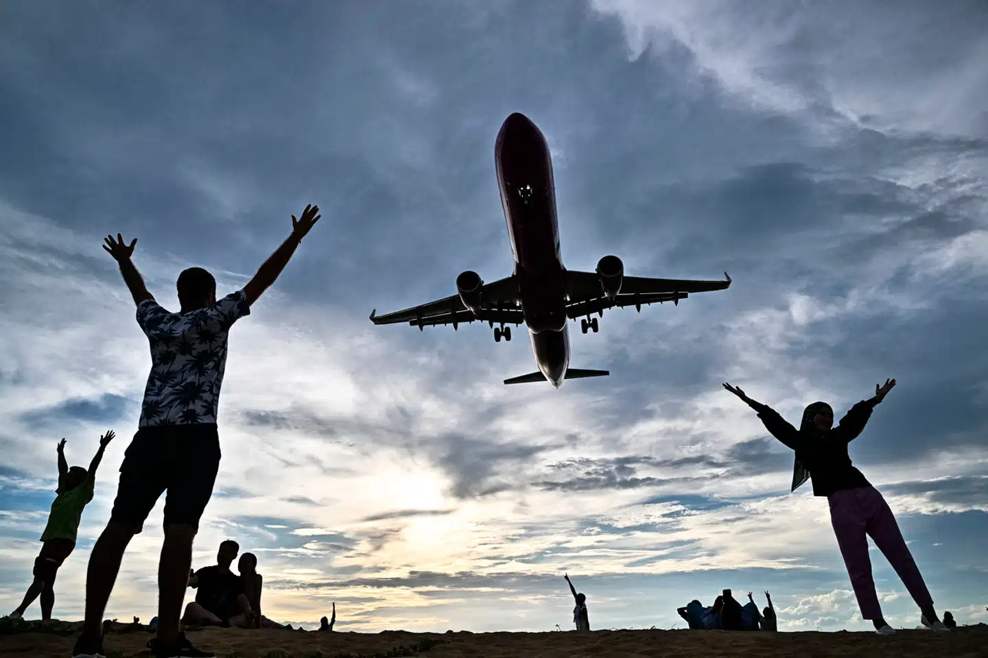 Vi flyver i disse dage som aldrig før, og aldrig har man målt en varmere klode. Men begejstringen for fly vil næppe kølne foreløbig. Strandgæster nær lufthavnen på Phuket i Thailand.