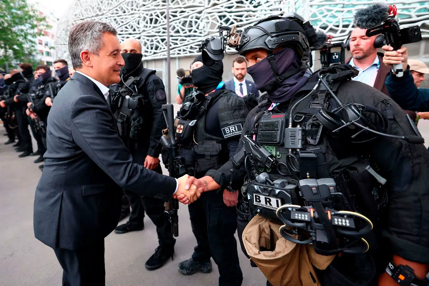 Indenrigsminister Gérald Darmanin hilser på medlemmer fra politiets særlige indsatsgruppe, BRI, posteret uden for Parc des Prince-stadion.