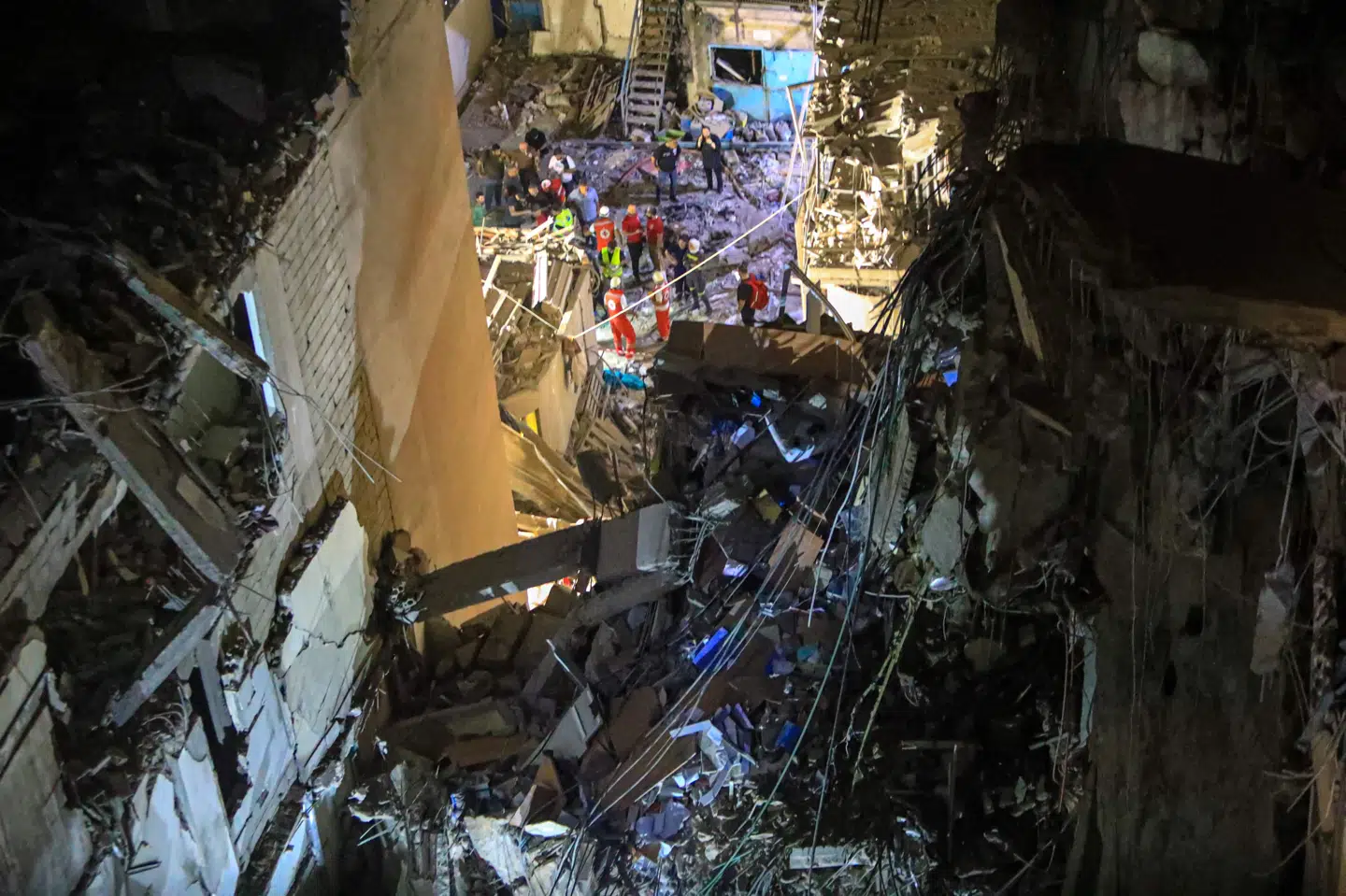 Redningsmandskab arbejder på gaden ved en bygning, hvis øvre etager er ødelagt i et israelsk angreb mod en Hizbollah-kommandant i Beiruts sydlige forstæder tirsdag.