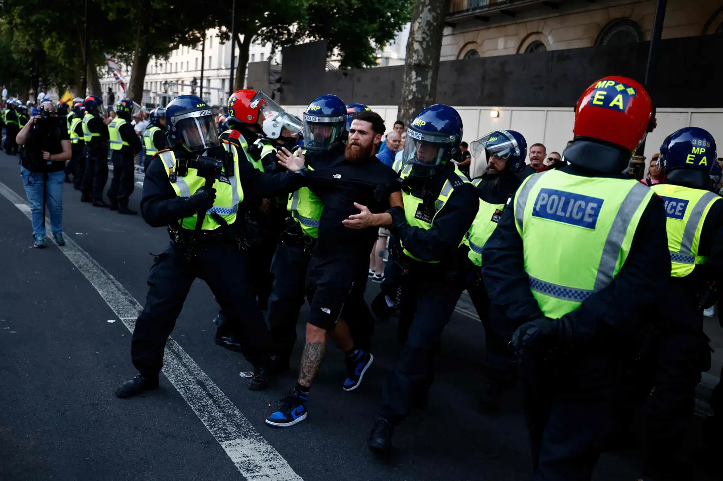 Betjente holder fast i en demonstrant under protester ved premierministerboligen i Downing Street nummer 10.