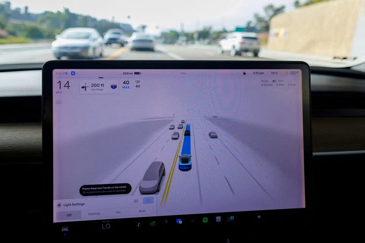 Systemet »Full Self-Driving« (Fuldt selvkørende) ses her i funktion i en Tesla Model 3. Det advarer føreren om at holde hænderne på rattet og være klar til at overtage til enhver tid, når det er slået til.