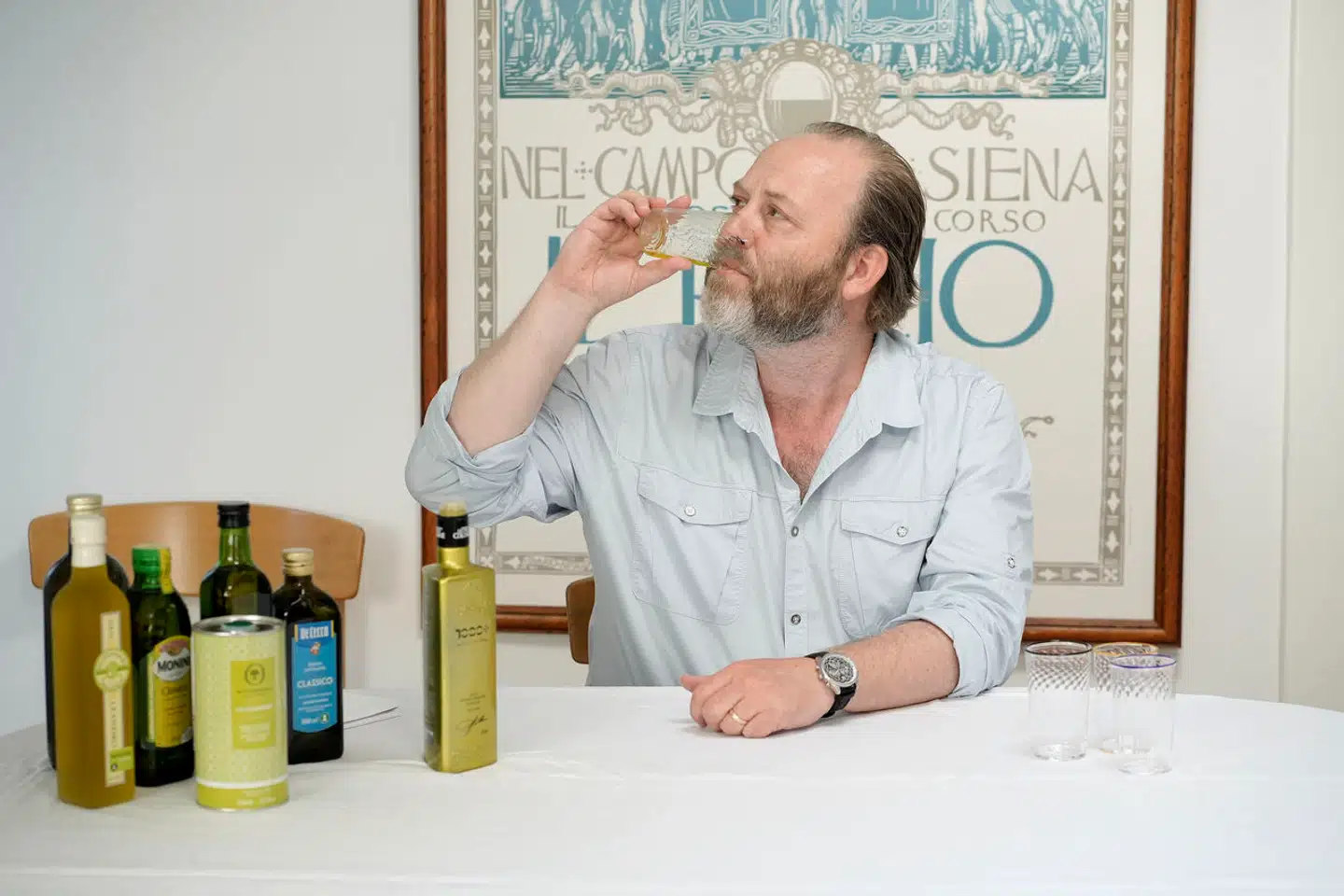 Berlingskes gastronomiredaktør, Søren Jacobsen Damm, med de syv olivenolier, der senere blev testet. Damm fik hjælp med at sætte smagningen op, så han ikke vidste, hvilke olier han testede, da han tildelte stjerner.