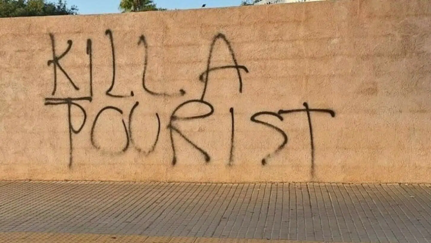 Sådan ser det ud på væggen i byen Manacor lige nu, hvor dele af den lokale befolkningen i længere tid har været mere end almindeligt trætte af de mange turister på øen. Foto: Foto: Paco Freire / Sopa Images / Shutterstock