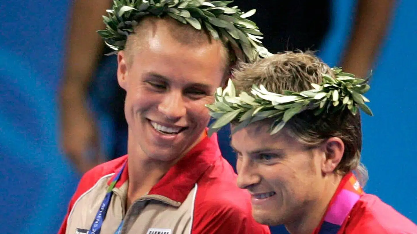 Finn Tugwell og Michael Maze med kranse på hovedet og bronzemedaljer om halsen.